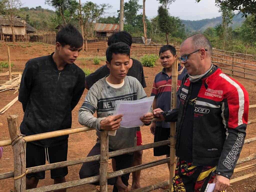 handing-letter-of-introduction-to-villagers-looking-for-crash-sites-along-the-trail-laos